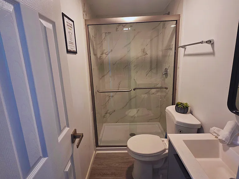 Spacious shower with bath mat and towel racks provided