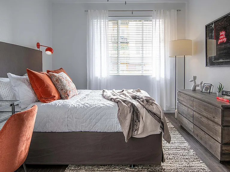 Spacious apartment bedroom with wood floors.