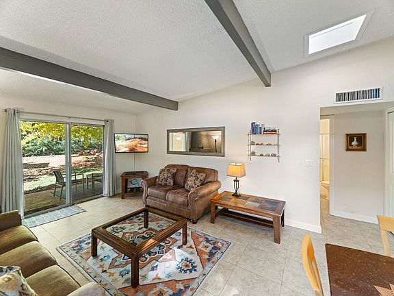 Vaulted Ceilings with skylights bring in lots of natural light. View to patio and Greenbelt.