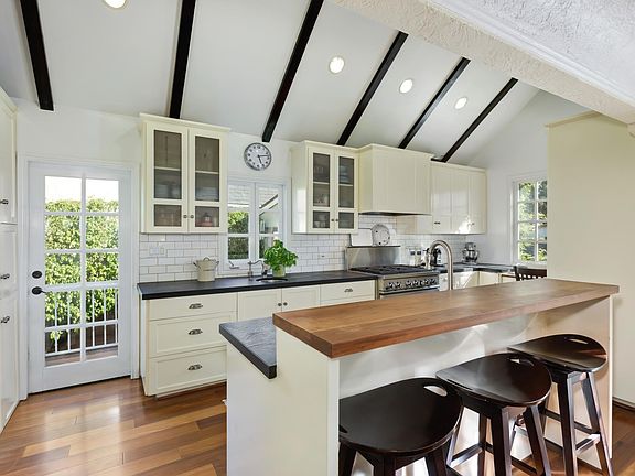 Kitchen with all appliances. Contain professional range, 2 sinks, bright desk area.