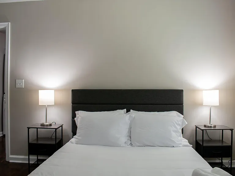 Furnished bedroom with a full-size bed, matching nightstands, and bedside lamps for comfortable nighttime reading.
