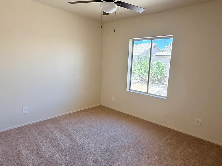 well-sized second bedroom perfect for family, guests or office space featuring hanging closet doors and built-in storage shelves