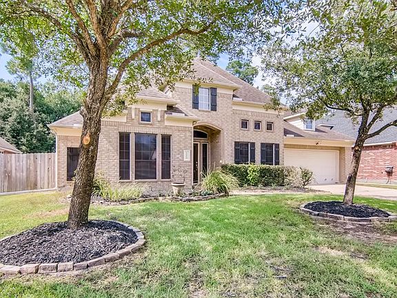Beautiful trees in front yard and shrubbery that accents the all side brick home