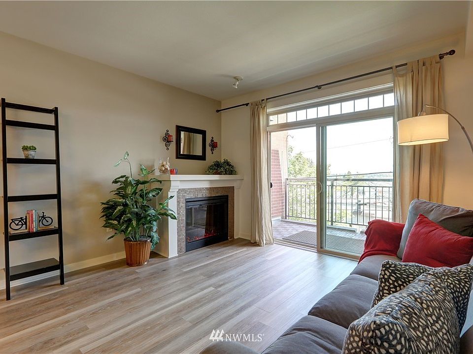 Welcome to the Roycroft Building! Living room with electric fireplace and a private patio. Relax in the morning as you watch the sunrise and enjoy the Cascade Mountain range.