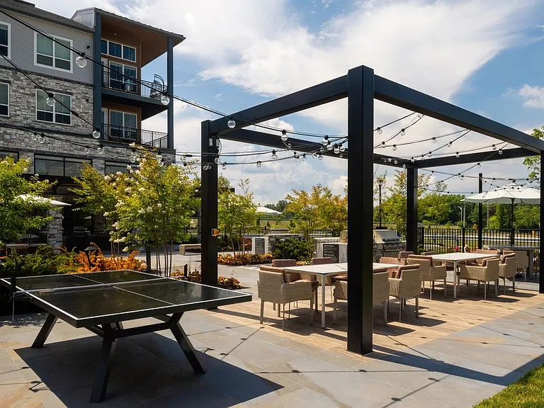Pool courtyard with BBQ grills, picnic areas, and ping pong table