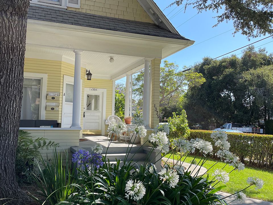 The front hedged-in yard and lush landscaping with the large welcoming porch. The entrance to the upstairs is on the right. You enter the private foyer and ascend the classic staircase, which leads you to the spacious apartment above.