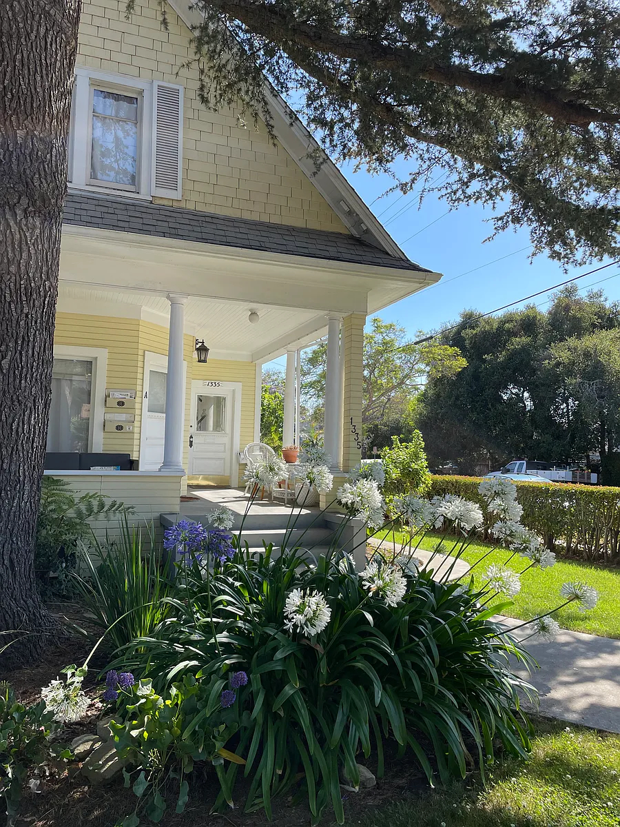 The front hedged-in yard and lush landscaping with the large welcoming porch. The entrance to the upstairs is on the right. You enter the private foyer and ascend the classic staircase, which leads you to the spacious apartment above. - 1135 Bath St #C