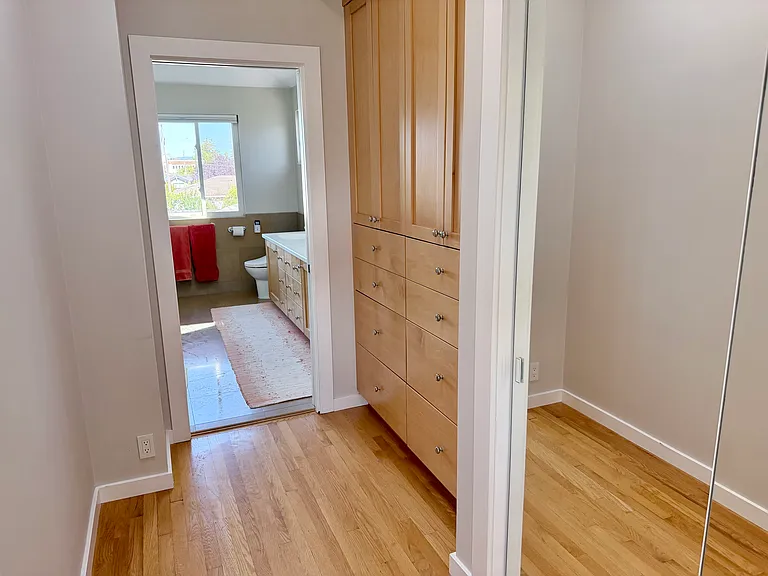 Mirrored closet and built-in cabinets in hallway to master bath