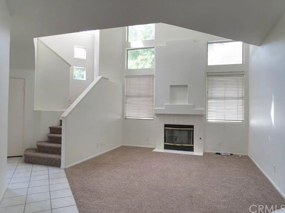 Two story living room with lots of window and light. The en
