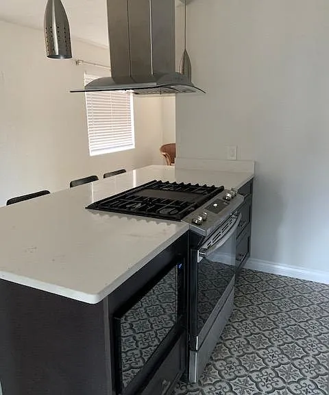 This four burner gas stove with built-in grill is just waiting to be fired upt! The stainless and glass vent has controls on both sides. Lots of counter space for cooking and serving.