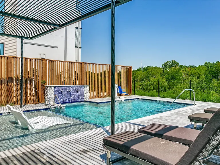 Private community pool overlooking the scenic blue trail and greenbelt, creating a tranquil setting for relaxation.