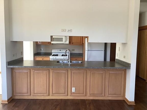 Front view of kitchen area with bar sitting