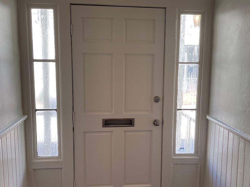 Interior front door freshly painted white trim and wainscoting with grey walls