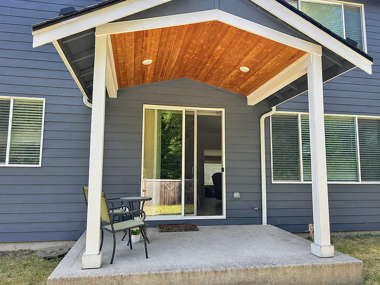 Covered back porch with fenced in lawn
