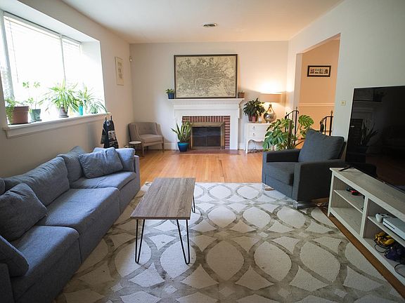 Sunken living room with bay window and hardwood floors.
