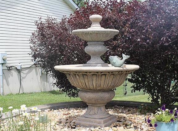 This fountain is 5 feet tall and it stays with the house.  The pump needs to be replaced and then with a flip of a switch you will have a beautiful fountain flowing.
