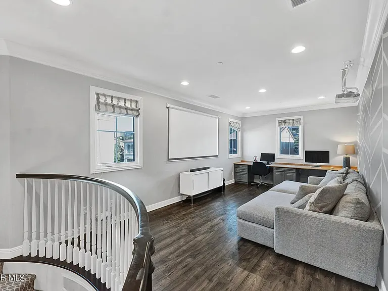 Loft with projector screen, sound bar, and office desk.
