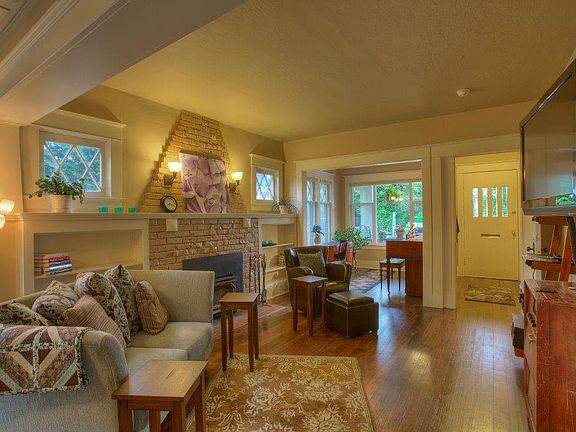 wonderful Living Room! cozy brick fireplace with built in bookcases. Original millwork and fir floors through out