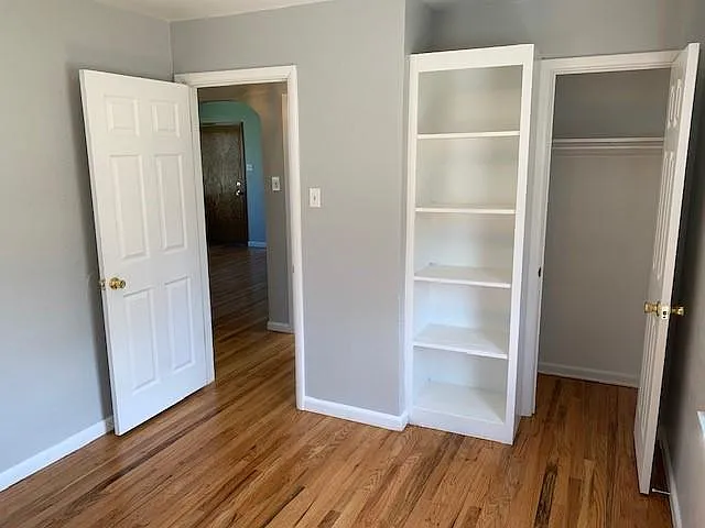 2nd bedroom with built-in storage shelf and closet