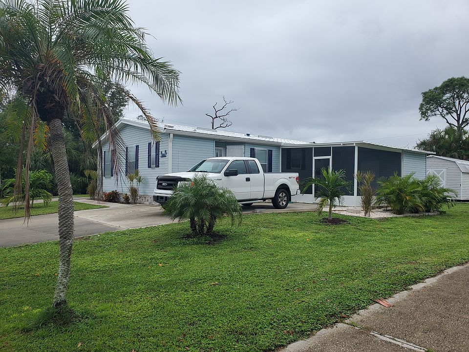 Exterior view shows long driveway and screened in lanai. Home has side, front, and back door access.