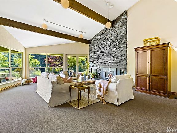 The cathedral beamed ceiling frames the expansive window wall which overlooks the organic gardens and heritage fruit trees with the trellised grape garden.