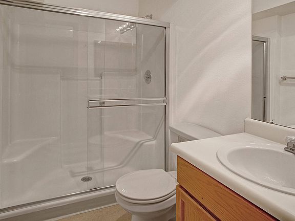 A bathroom with cabinet storage and a large standing shower