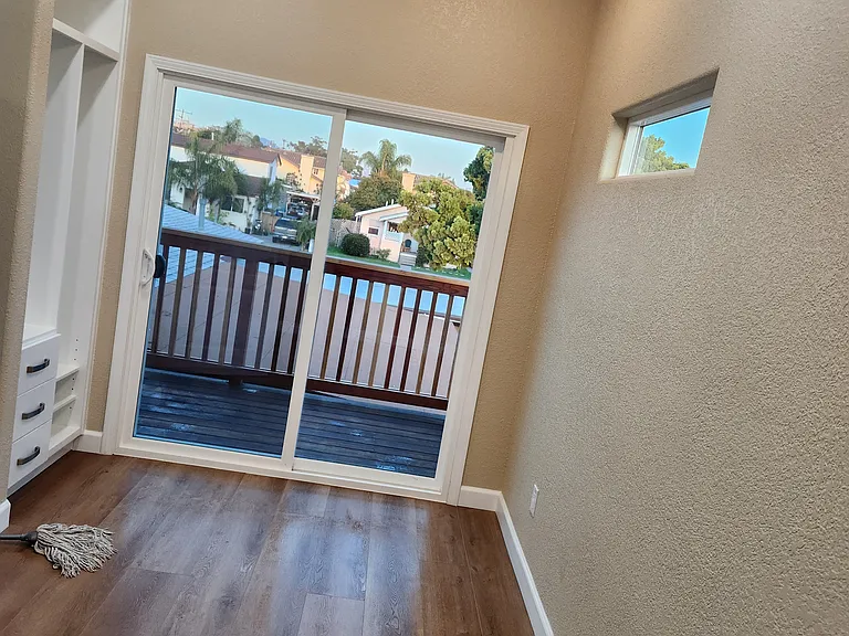 View of the balcony and built-in closet from master bedroom and natural light from two windows.