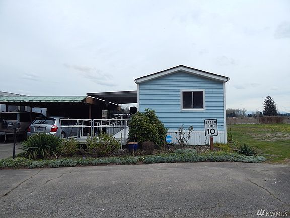 another view of the front of the home lot next to it is vacant , carport is shared with storage in the back. 