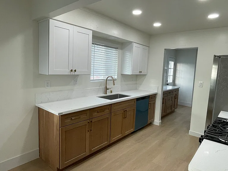 Kitchen featuring quartz countertops, custom cabinetry, Delta fixtures, and recessed dimmable lighting