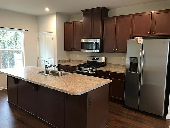 Kitchen with SS appliances, pantry and extended island.