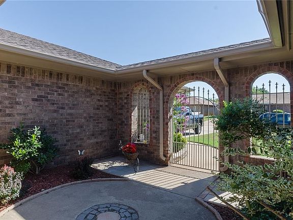 Pretty courtyard with wrought iron gate and nice landscaping.