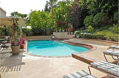 Pool and spa in the backyard, with a gorgeous slope and covered