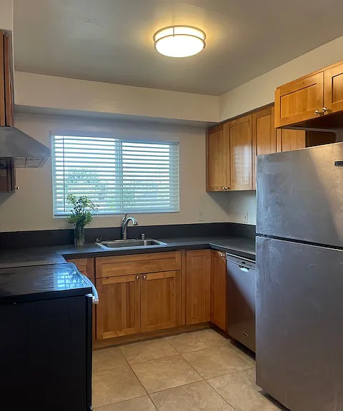 Beautifully remodeled eat-in kitchen with maple shaker cabinets, tile floors, quartz counter tops. stainless steel appliances including electric stove, dishwasher and refrigerator. Natural light through the window above the kitchen sink. LED lighting.