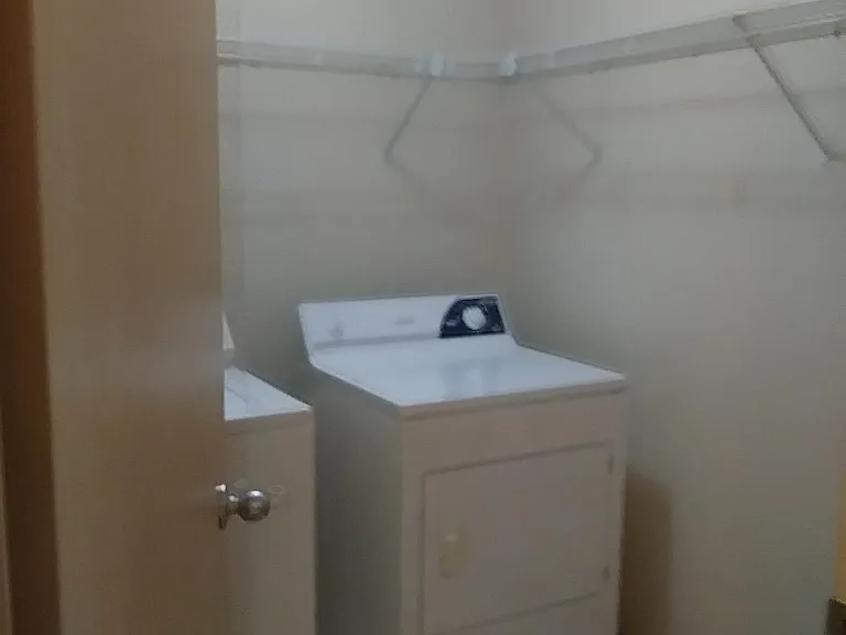Laundry room, newer washer and dryer, ample shelving area.
