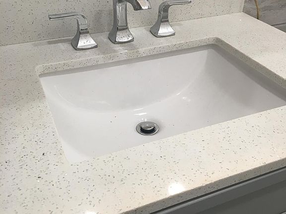 Quartz sink in bathroom with Kohler faucet