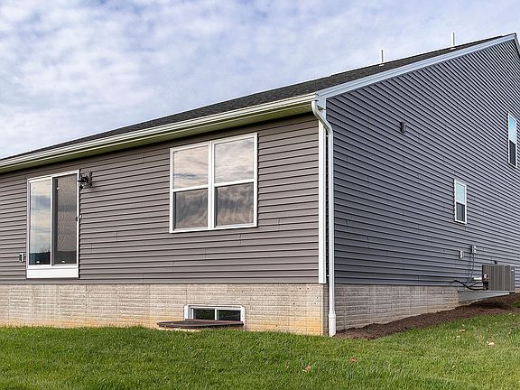 Rear view of the Ashwood floorplan - vinyl siding, sliding glass door and two windows on the back wa