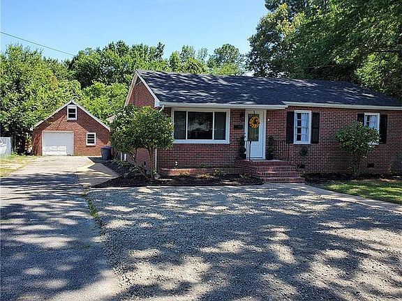 Front of home- Welcoming entrance to home with plenty of parking. The extended driveway and gravel parking area can fit up to 6 vehicles.