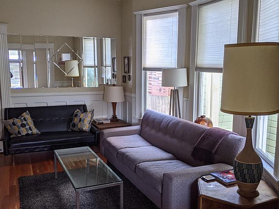 Living room with comfy couches and lots of light, tall ceilings