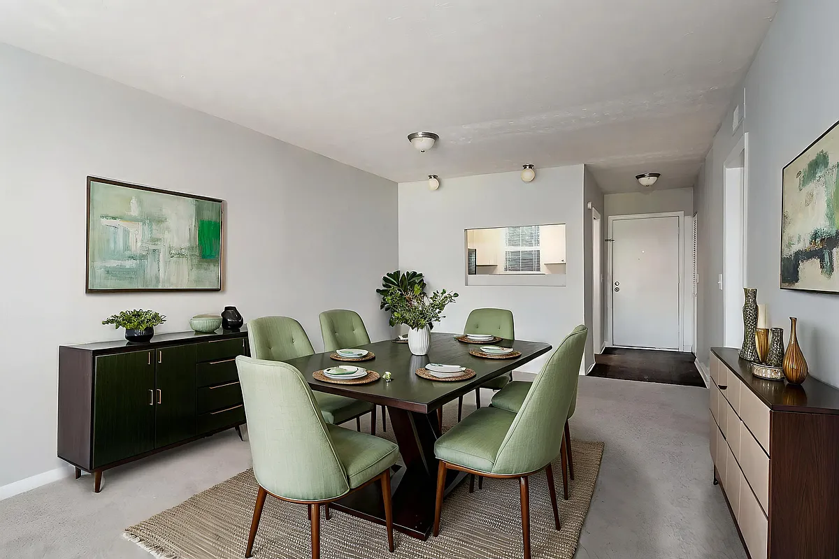 Elegant dining room with a modern green theme, featuring a stylish dark wood table, matching chairs, minimalist decor, and contemporary artwork. - Prospect Heights