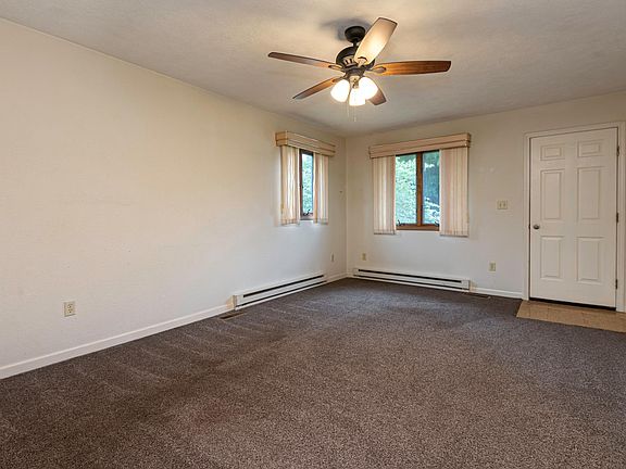 Kitchen view into Living area. Vertical blinds have been replaced with curtain rods and will have 1 inch mini blinds installed.