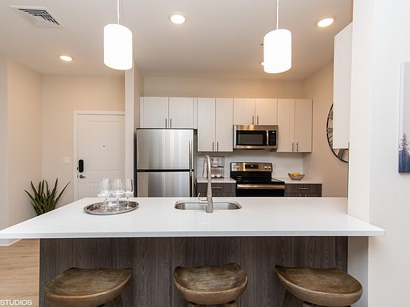 Gorgeous kitchen space with quartz white countertops and stainless steel appliances