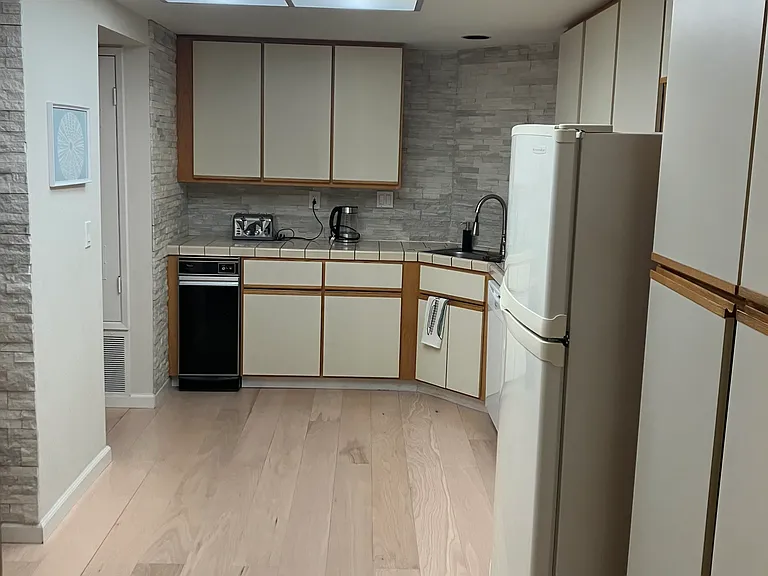 Kitchen with new hardwood floors and marble tiled walls
