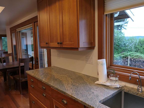 1 of 3 portions of large kitchen. view is SW. On the left side of picture is dining room table and 2 exits to the outdoors and the Ice deck.