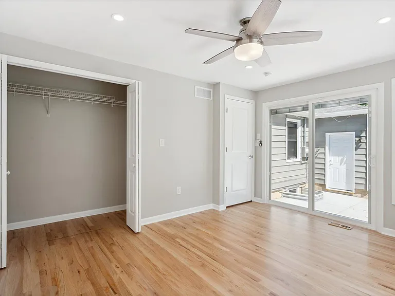 Large Primary Bedroom Closet w/ Private Access to Back Yard. Windows Have Built In Blinds.