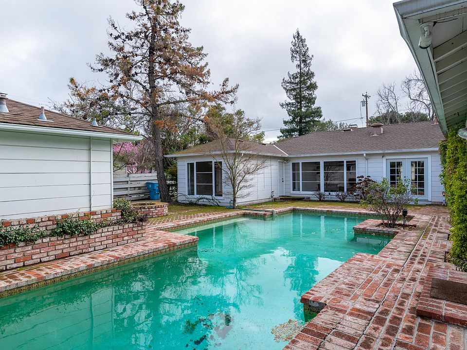 We start our tour in the back yard with a look at the pool. The property surrounds it: to the right of the pool are two bedrooms; at the far end of the pool are the living areas and two more bedrooms; at the left is the ADU and garage.
