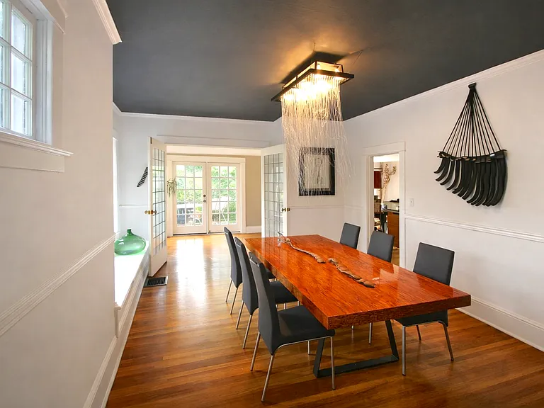 Dining room looking through sunroom to outside deck (facing West). Custom glass art chandelier comes with house)