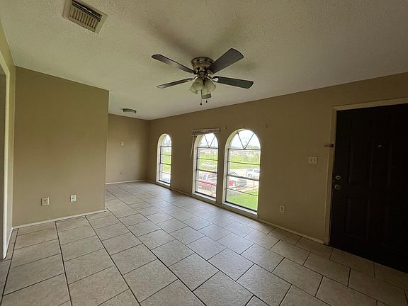 Living room with ceramic tile and ceiling fan.