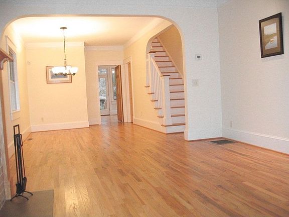 Dining room open to living area, separated by classic arched opening