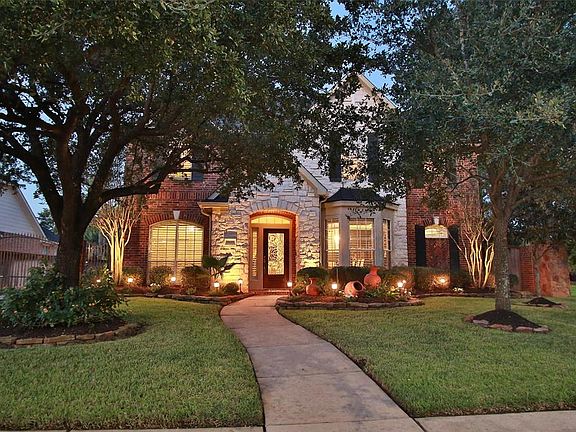 Mature trees offer much shade and welcome you to this Gleannloch Farms brick and stone Trendmaker home. Well landscaped too!