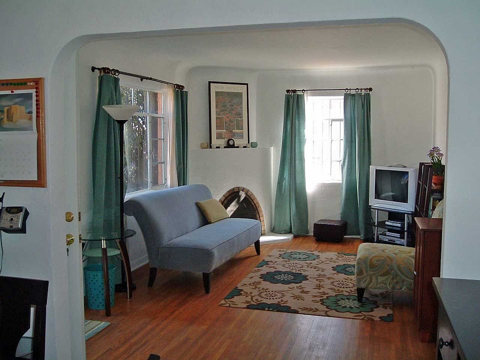Charming original details include hardwood floors, cove ceilings and arches